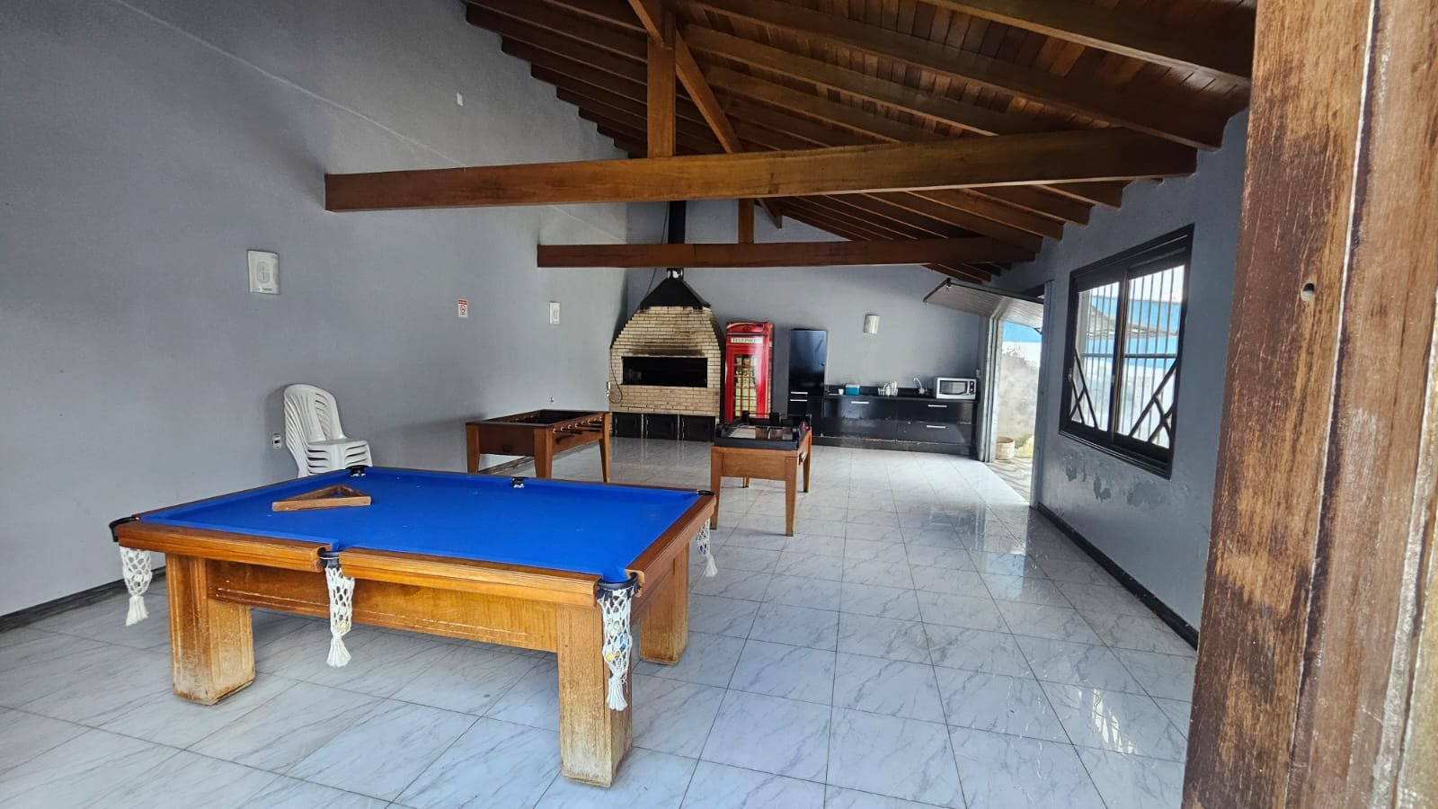 Sala de jogos com mesa de sinuca e pebolim