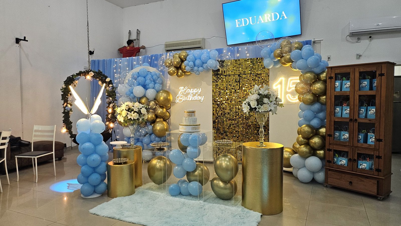 Decoração azul e dourada com letreiro neon 15 anos no Universo das Festas
